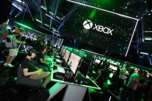 The green Xbox logo lit up above rows of players at an Xbox event